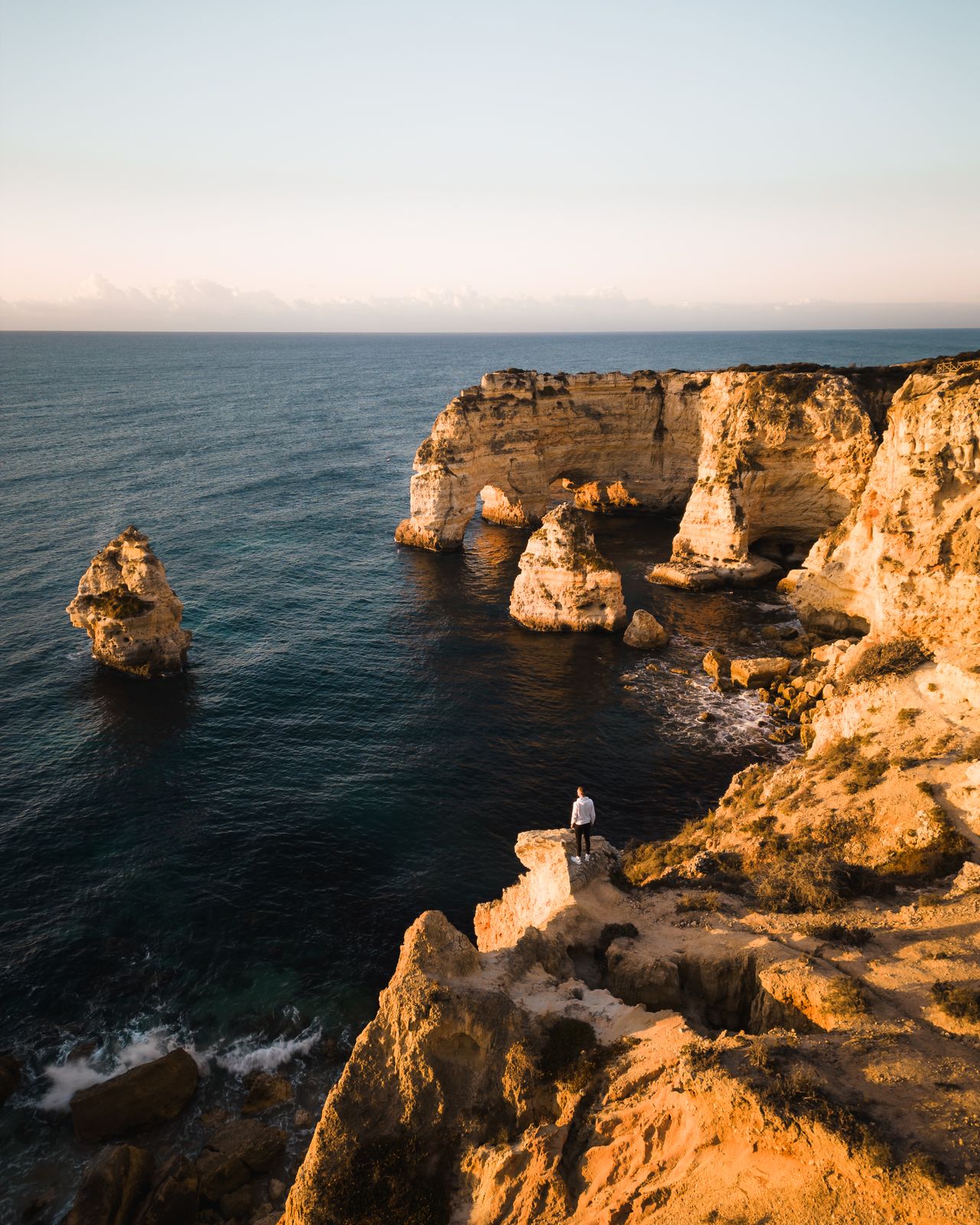 Turquoise lagoon enclosed by limestone cliffs from above