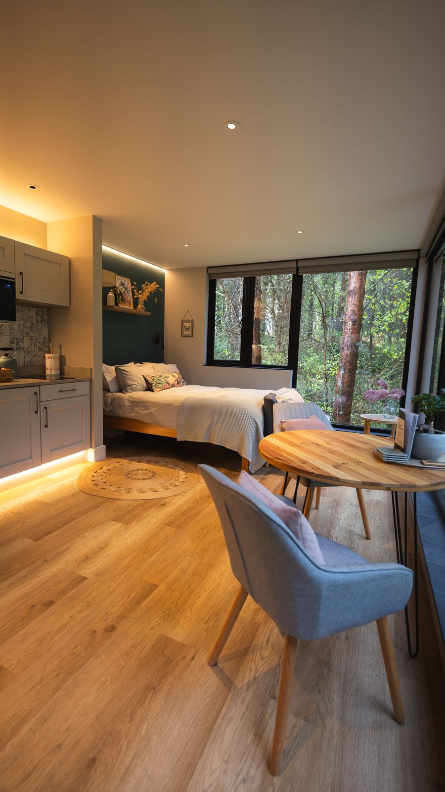 Bedroom corner with woodland framed in the glazing