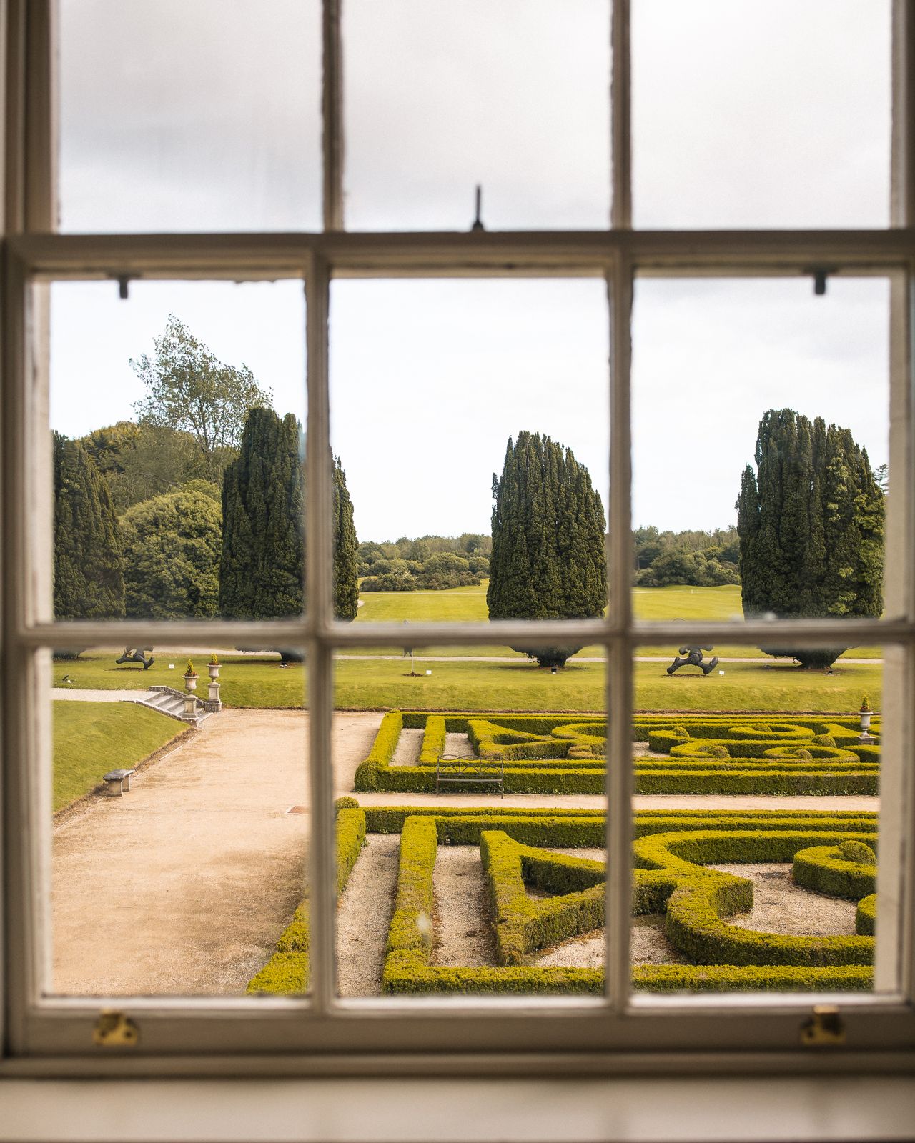 Formal parterre garden framed through a Georgian window