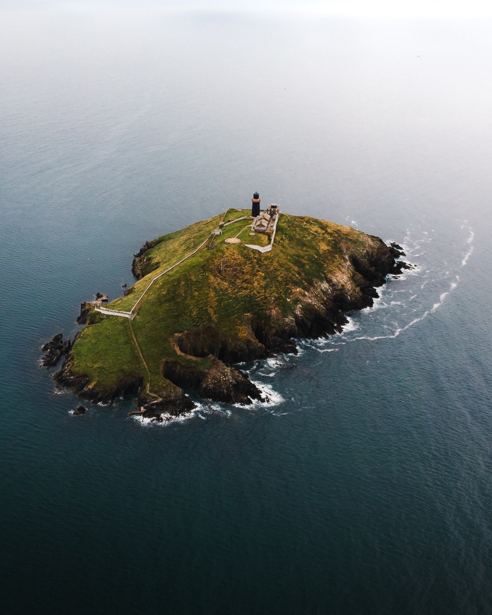 A small island with a ruined tower, alone in a misty sea