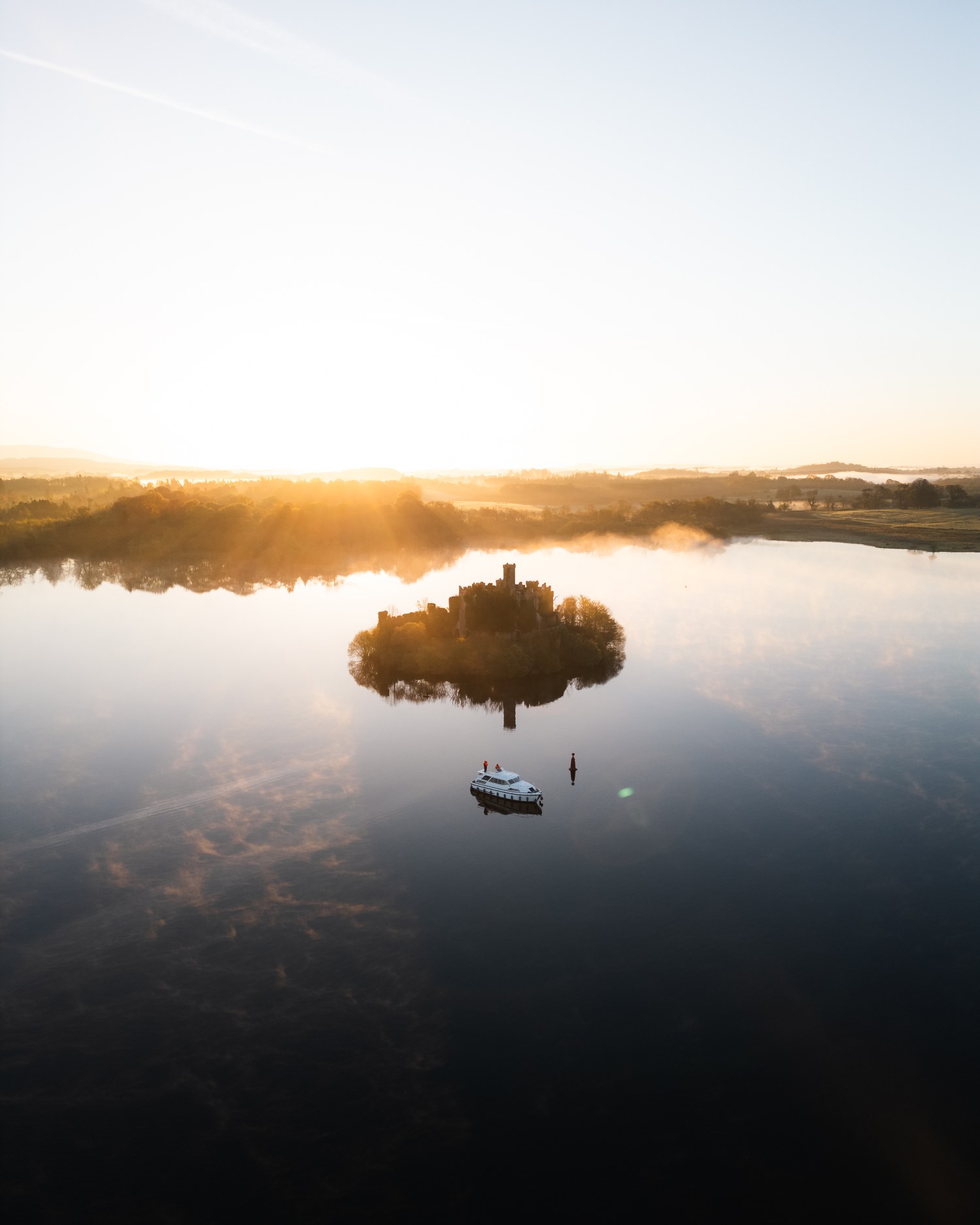 Sunrise silhouette of an island with a small boat