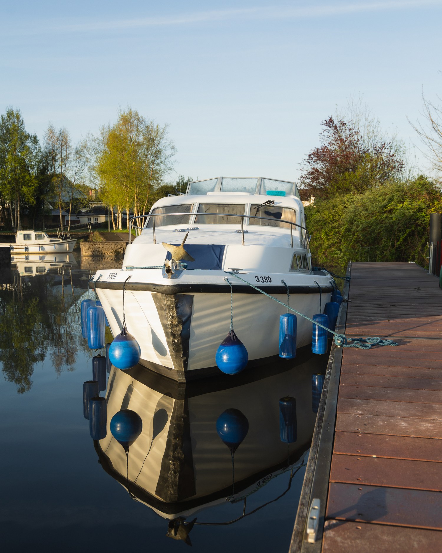 A cabin cruiser moored at a wooden dock