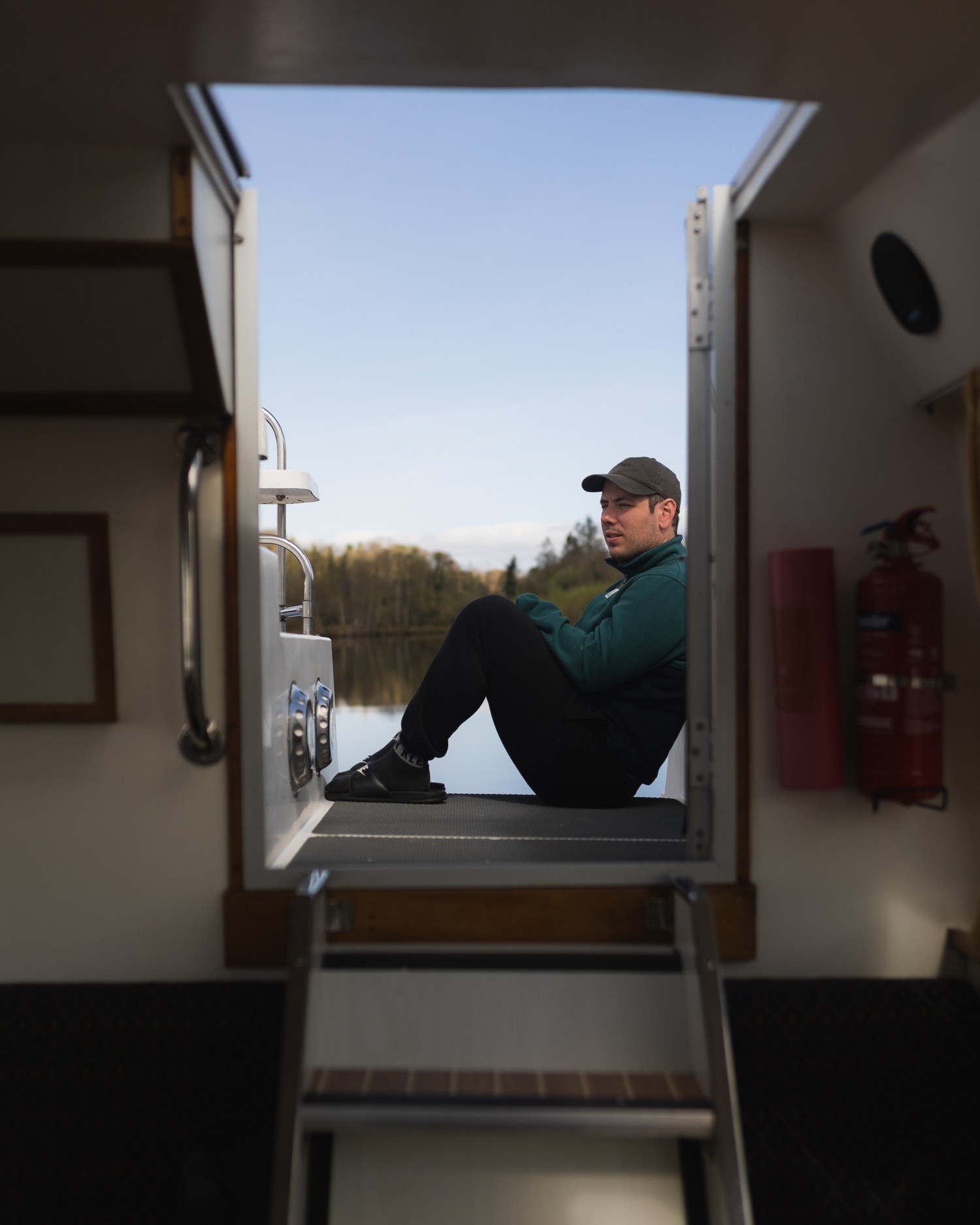 A traveller sitting in the doorway of a boat cabin