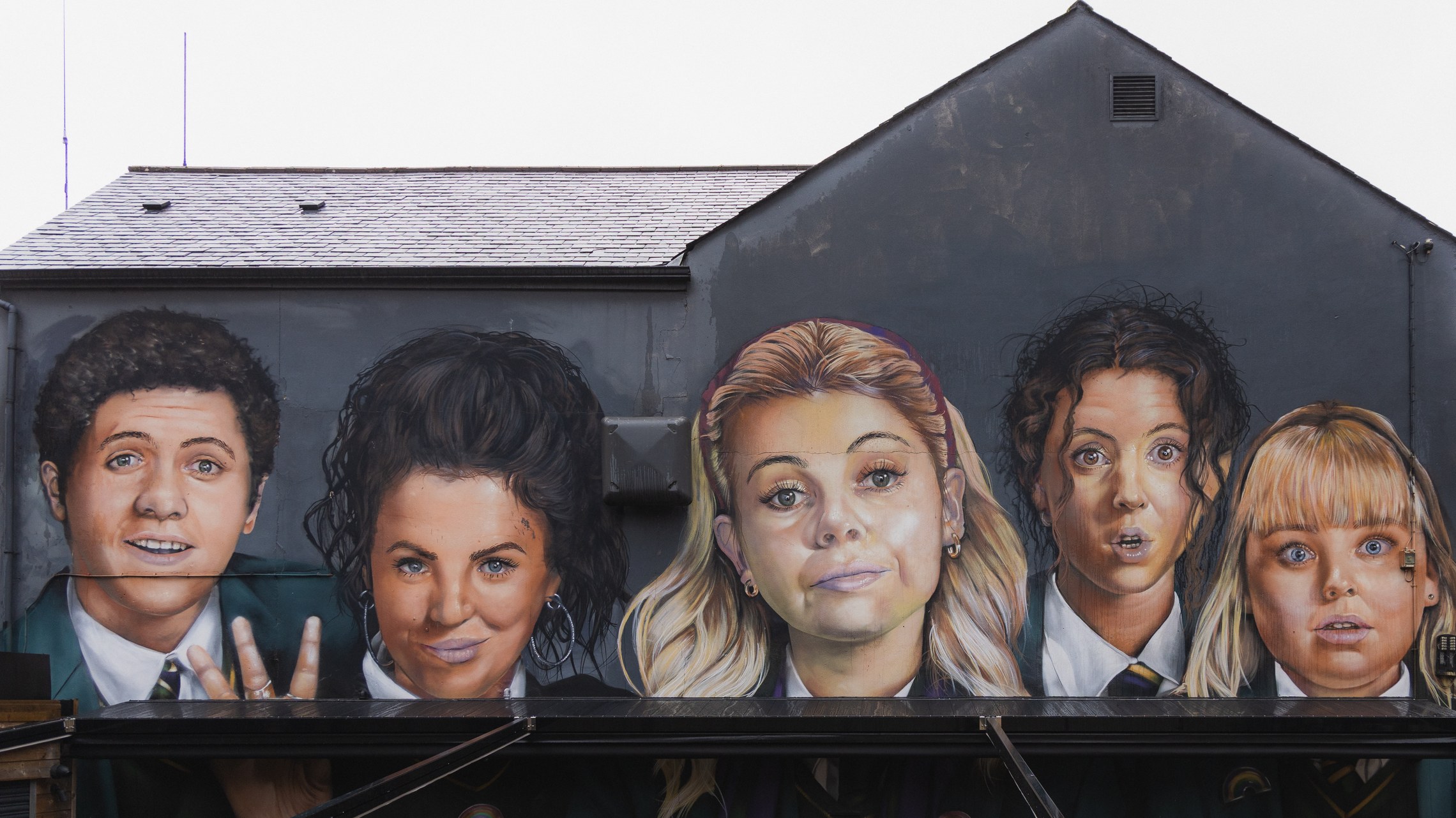 A large gable end mural of five figures on a city street