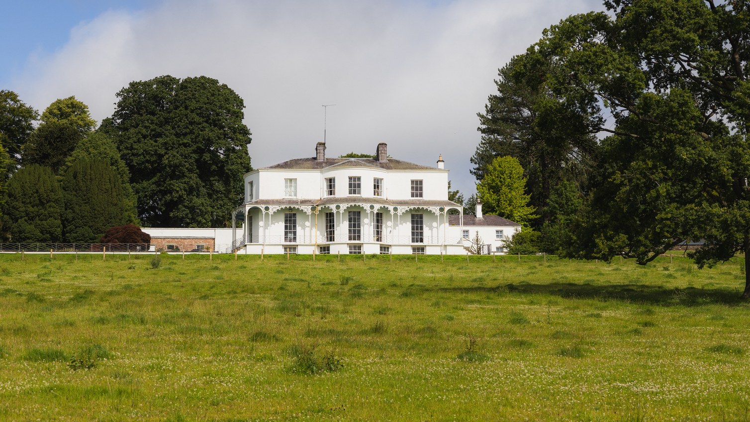 A white Georgian country house in its parkland
