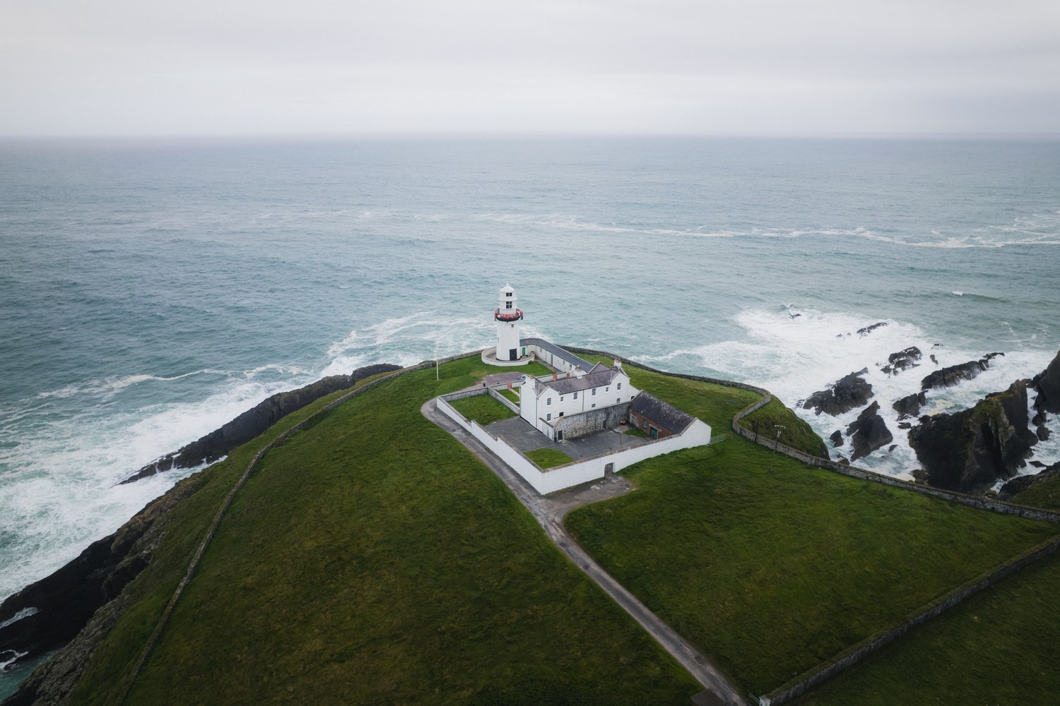 A lighthouse on a headland above a rocky coastline