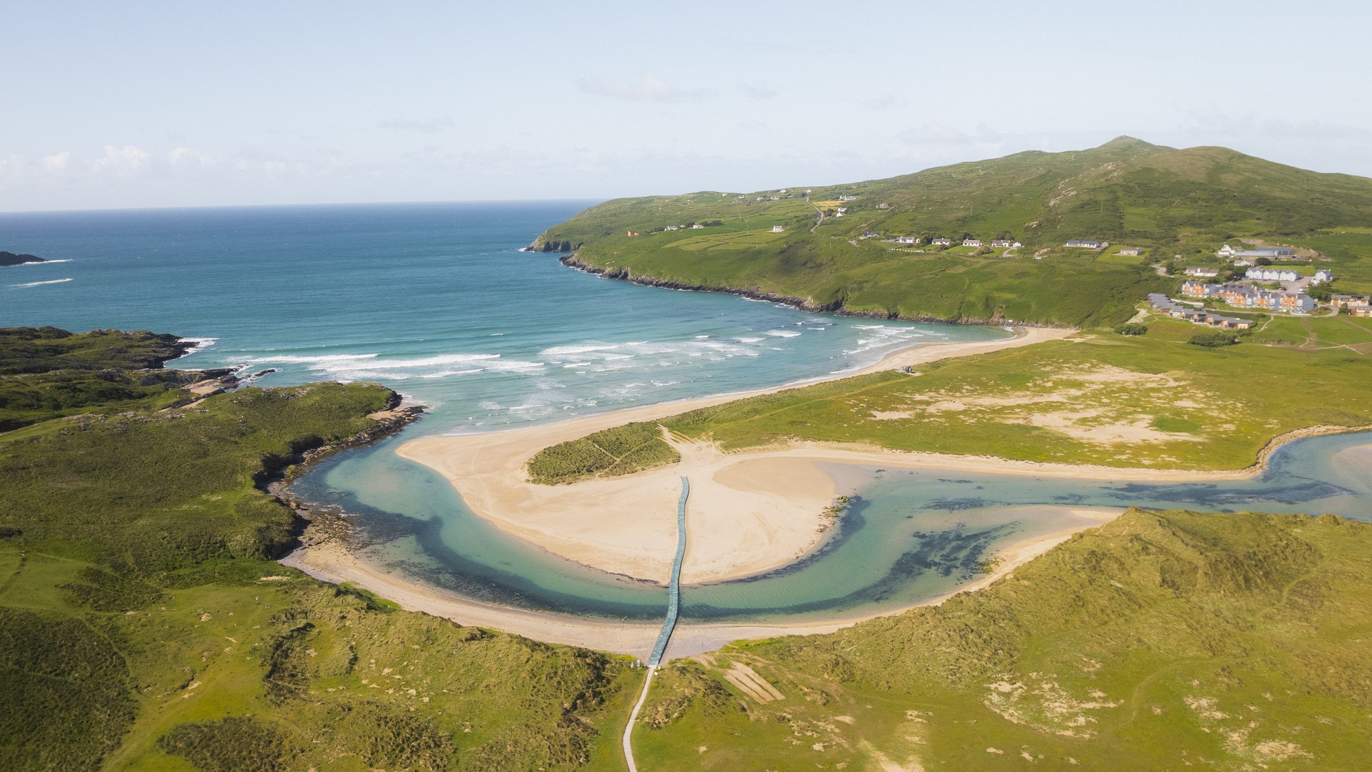 Aerial view of a wide sandy beach and its tidal channel