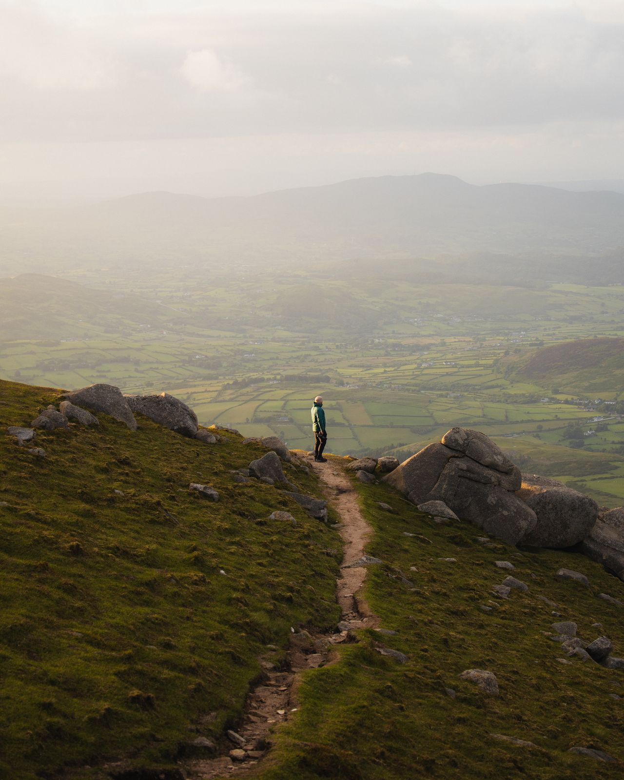Figure on a ridge path above a misty valley