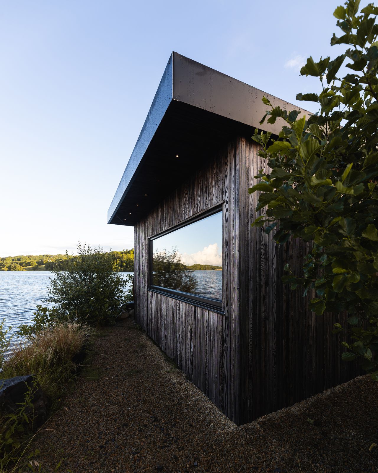 Timber cabin exterior at dusk beside the lake at Finn Lough