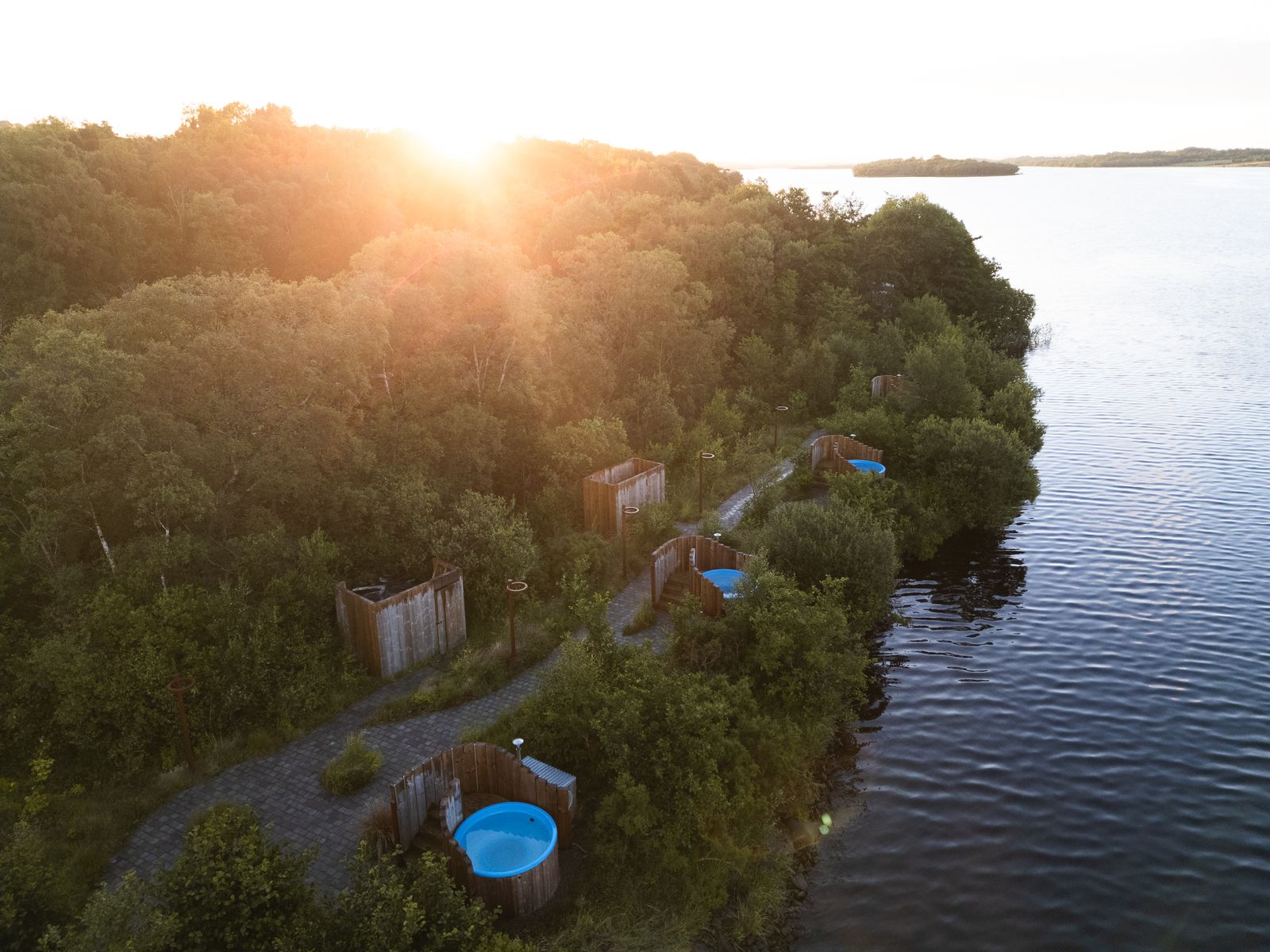 Aerial view of the Finn Lough forest and lakeshore at golden hour