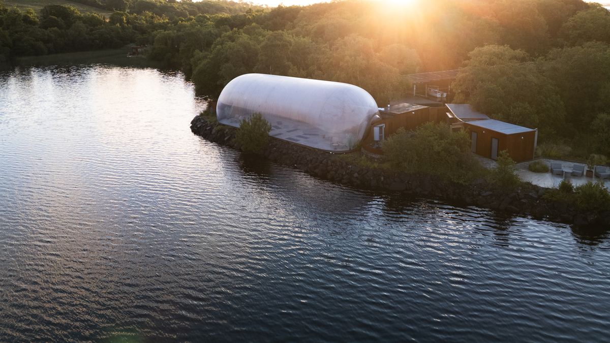 A Finn Lough bubble dome glowing at sunset beside the lake, Fermanagh