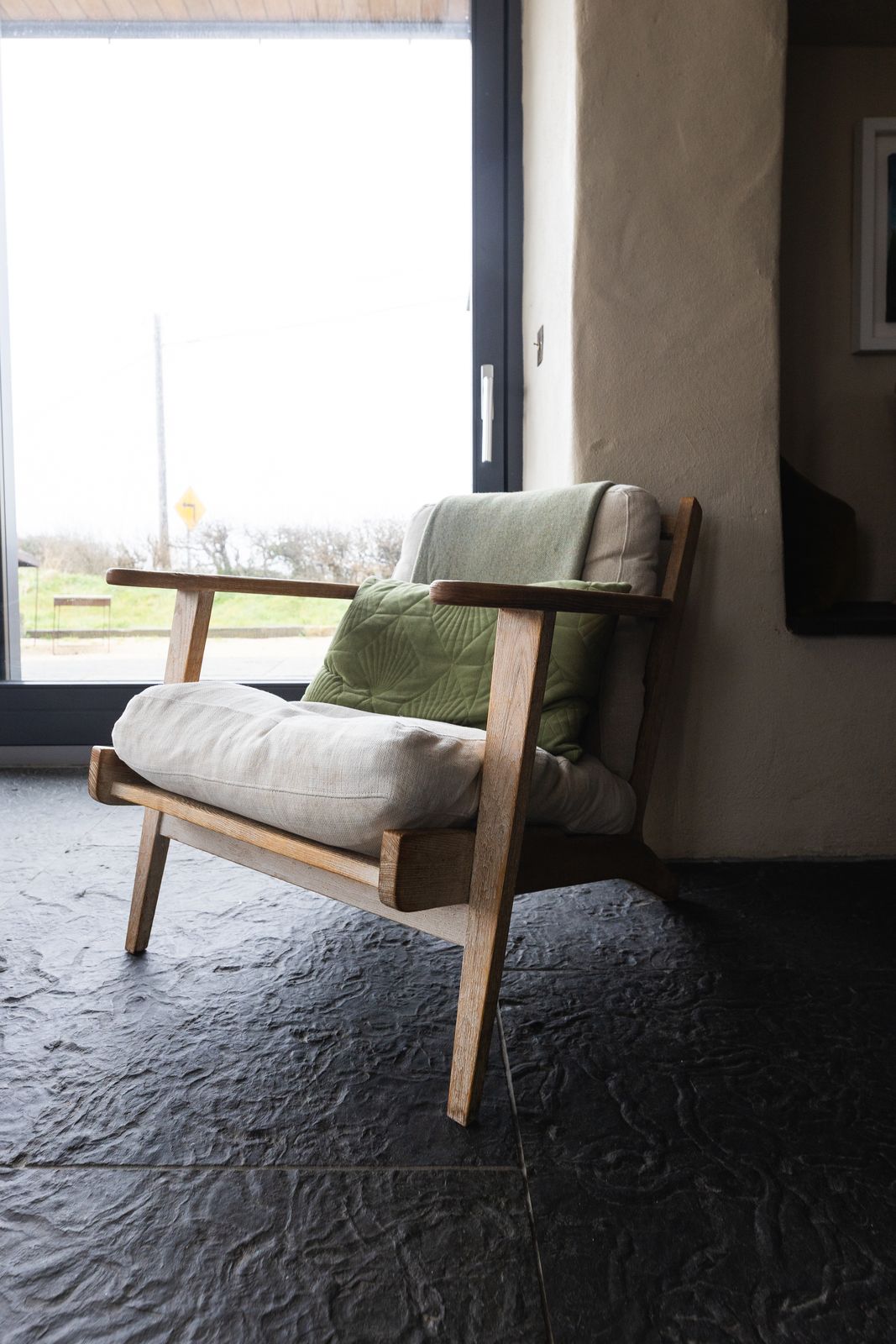 Armchair beside a window looking out to open fields