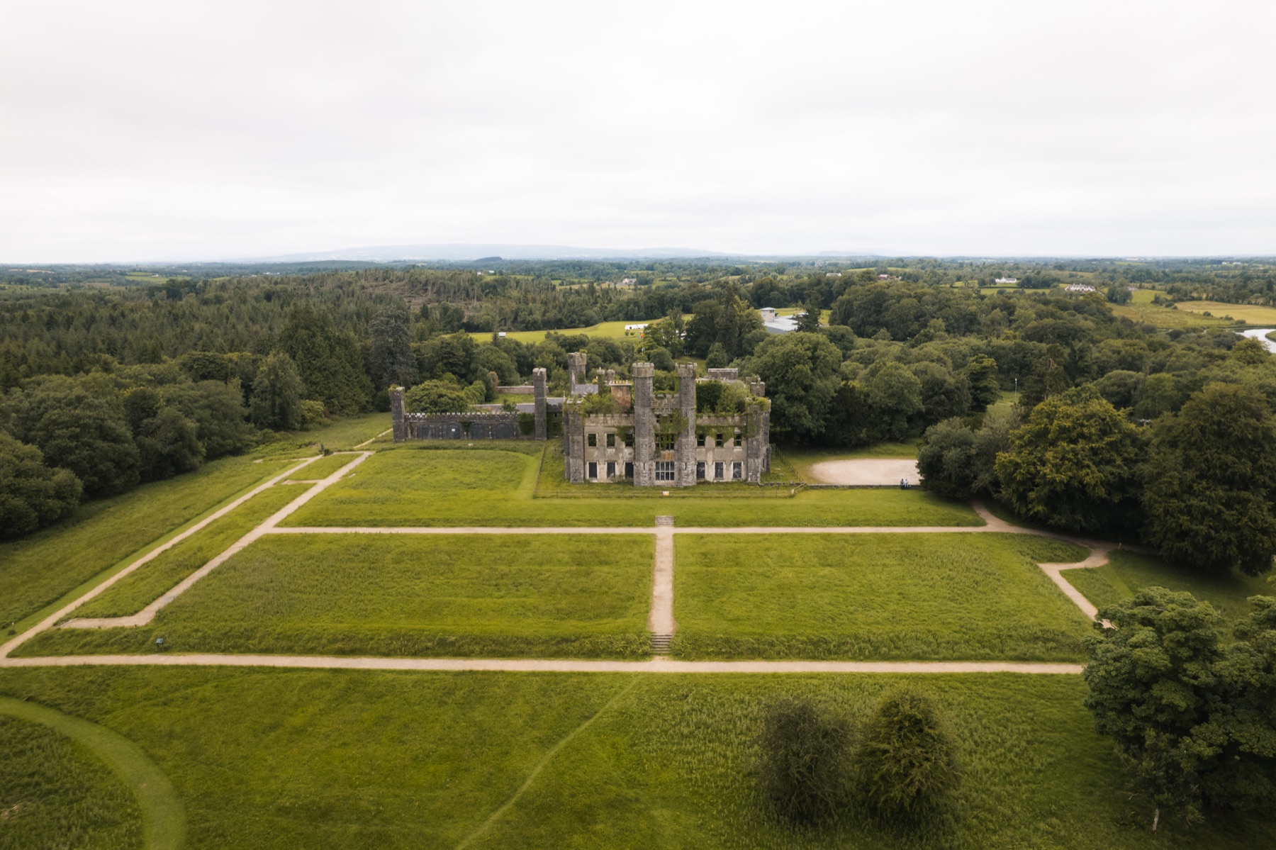 The ivy covered Tudor Gothic shell of Castle Saunderson beside the river, County Cavan