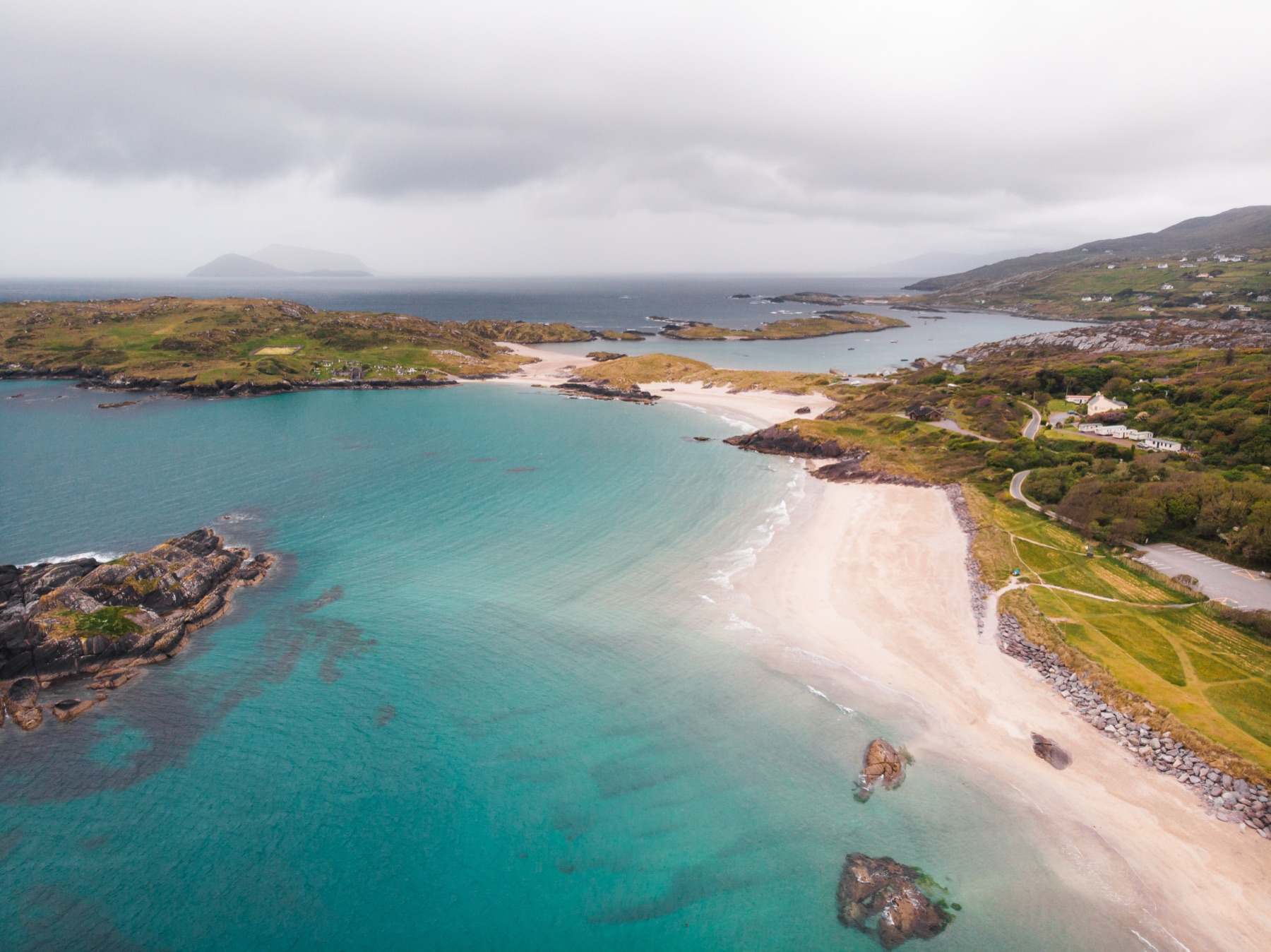 Turquoise water and pale sand at Derrynane Beach with Abbey Island beyond, County Kerry