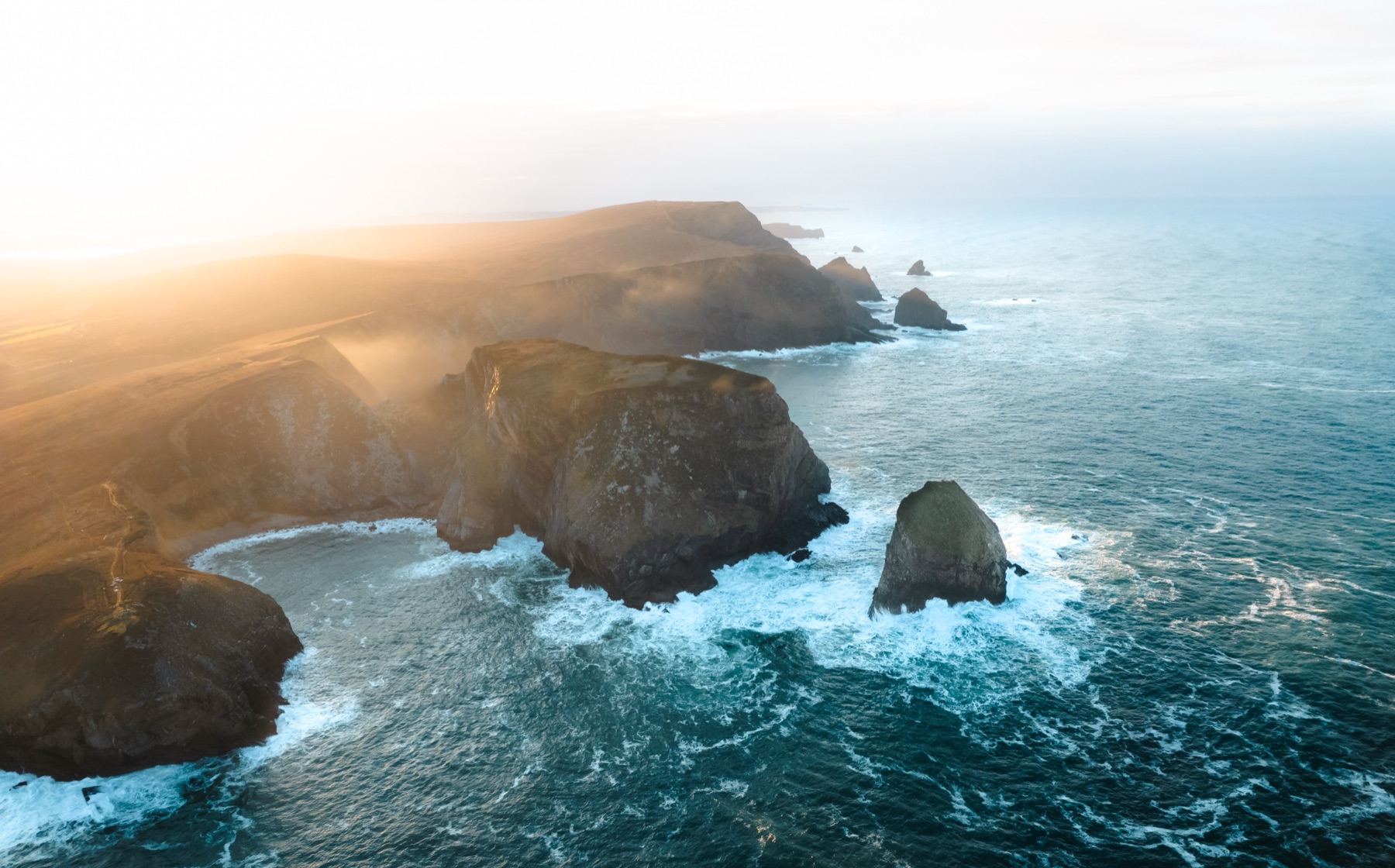 Aerial view of sea cliffs and stacks at Portacloy, County Mayo, at golden hour