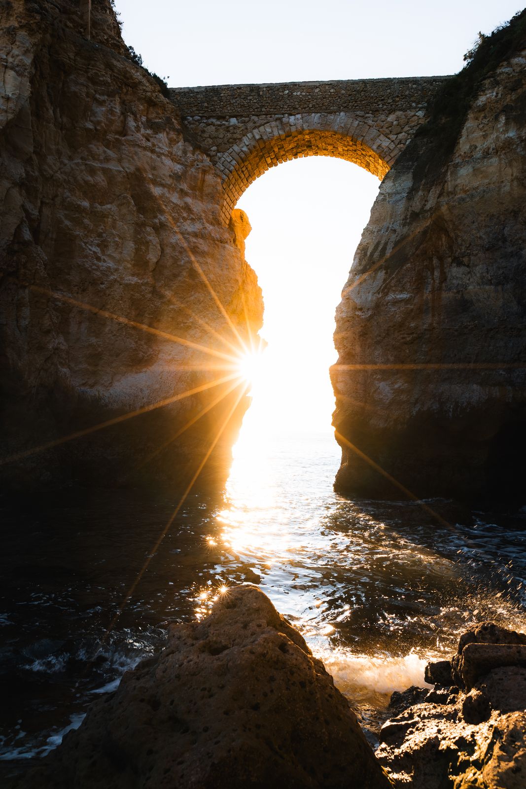 Sun star through a natural sea arch