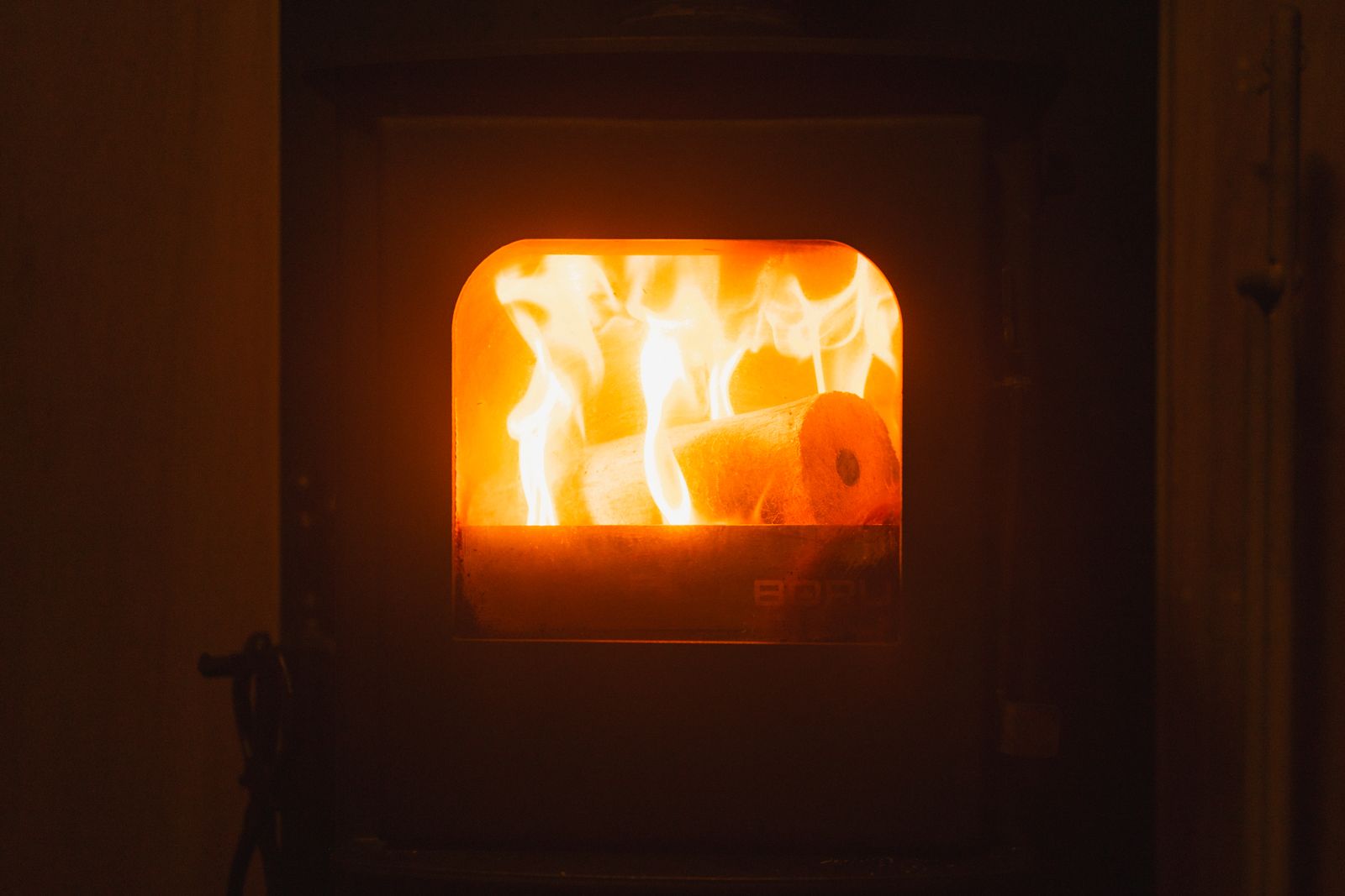 Fire burning behind the door of the wood stove